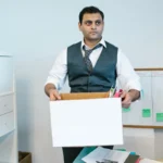 Karyawan merapikan barang pribadi di kotak kardus saat resign dari kantor